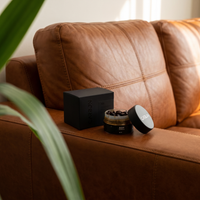 Carbon ASH ma'moul box and open jar on a leather sofa