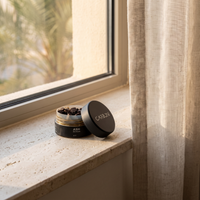 Open jar of Carbon ASH ma'moul on a stone windowsill