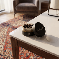 Open jar of Carbon ASH ma'moul on a white side table