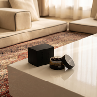Carbon ASH ma'moul box and open jar on a white table in a diwaniya