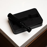 Carbon Ignis torch lighter on its open case on a white table