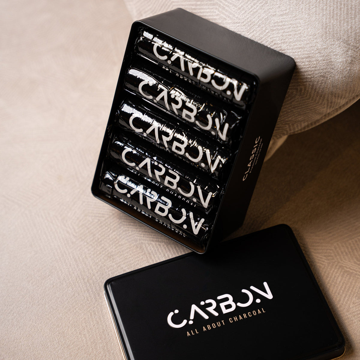 Carbon Classic charcoal rolls in an open black tin