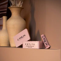 Carbon Petite tin and roll on a shelf beside ceramic vases