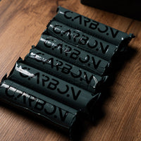 Carbon Max charcoal rolls lined up on a wooden table