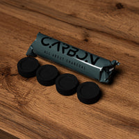 Carbon Max charcoal roll and four pieces on a wooden table