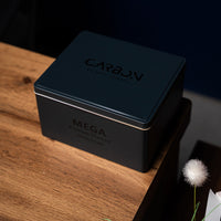 Carbon Mega navy tin on a wooden side table