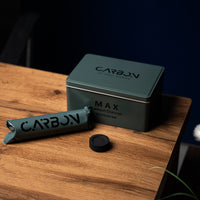 Carbon Max tin, roll and a charcoal piece on a wooden side table